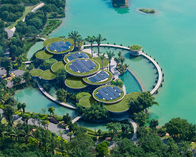 a cluster of circular green roofs top this lotus clubhouse over a vietnam lake