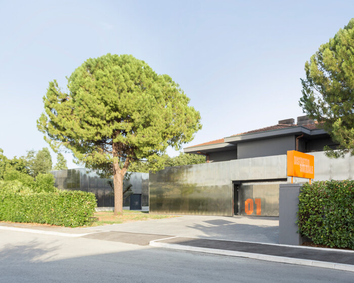 mirrored aluminum facade blurs distretto solidale social space into the italian landscape