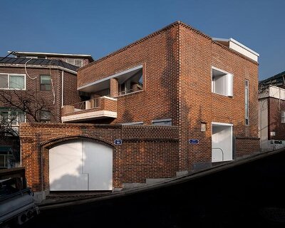 red brick and zinc reshape a 1970s house in seoul into a hybrid studio-home