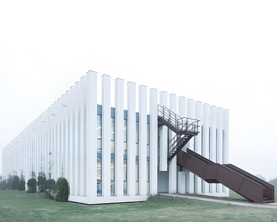 vertical white pillars compose rhythmic facade enfolding primary school in italy