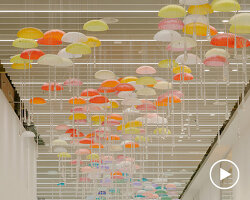 hundreds of suspended parachutes by lazerian drift above manchester airport’s terminal