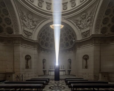 a beam of white light carves through paris' historical chapel