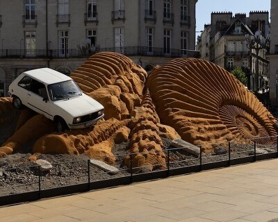 crushed cars emerge from monumental archaeological landscape in 'fossil opera'