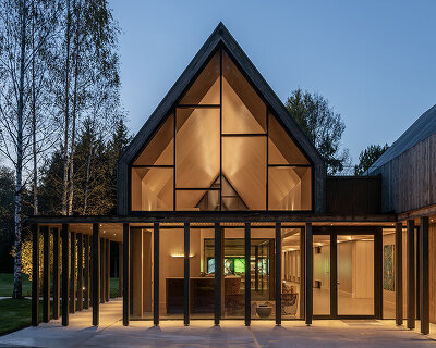 gabled timber volumes weave sanctum cabin retreat into the lithuanian forest