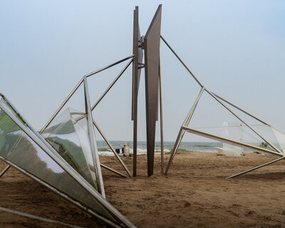 interconnected metal rods form a luminous winged installation on china's coastline
