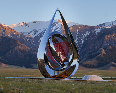 a mirrored water drop installation reflects the landscape of sayram lake in china