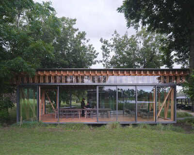 rhythmic timber and glass pavilion unfolds beneath pecan tree canopy in argentina