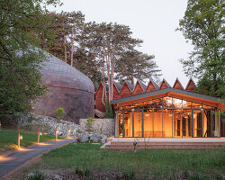 copper shingles wrap curving concert hall 'la source vive' in évian, france
