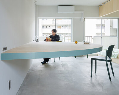 giant blue-green semicircular table by tato architects reorganizes kyoto apartment