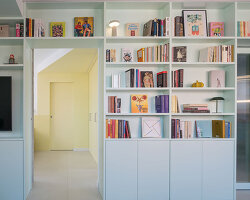 a sequence of colored rooms and a continuous bookcase reshape a madrid apartment