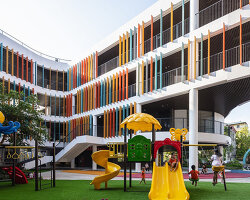 elliptical classroom volumes and colorful louvers shape courtyard kindergarten in hanoi