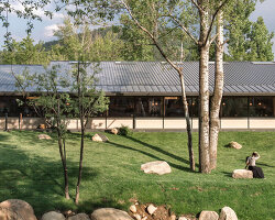 dark metal roof shapes community canteen beside mountain stream in china