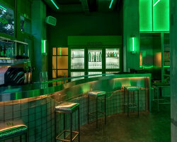 studiomateriality translates lucha libre into green-lit, stainless-steel bar in athens