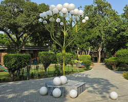 luminous globes extend from branched metal tree installation in pakistan