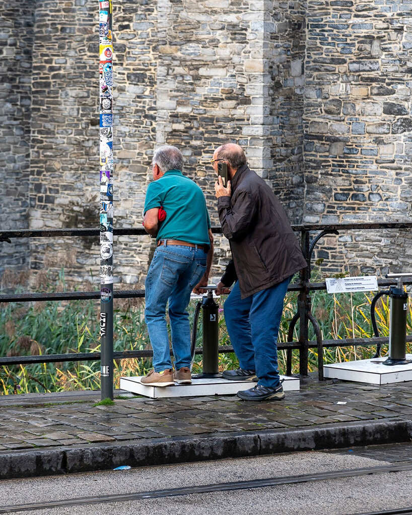 passersby stop to look at the sculpture