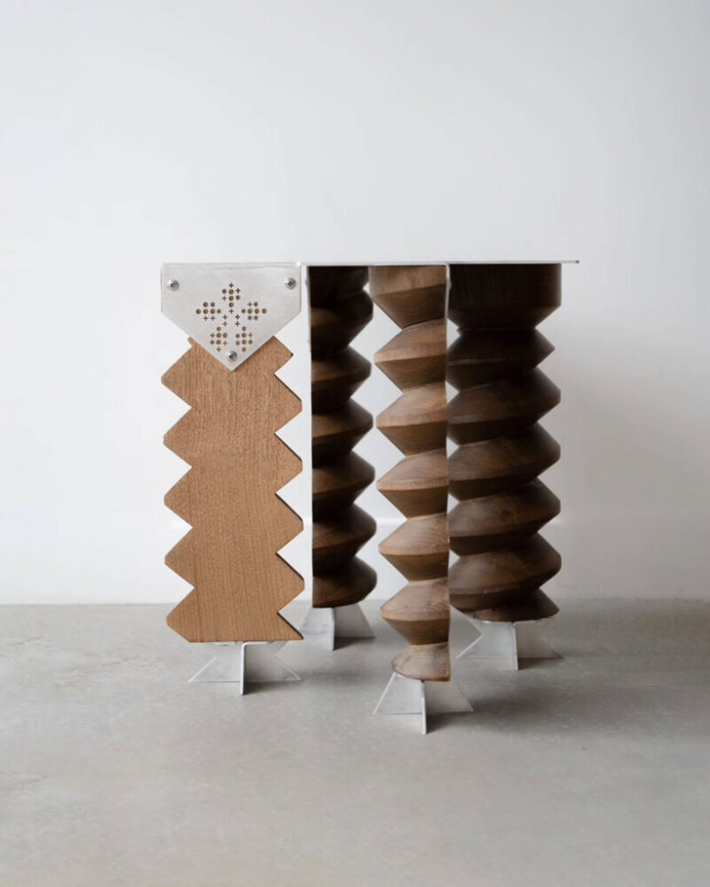 close-up of the stool’s weathered wooden screw legs and aluminum frame